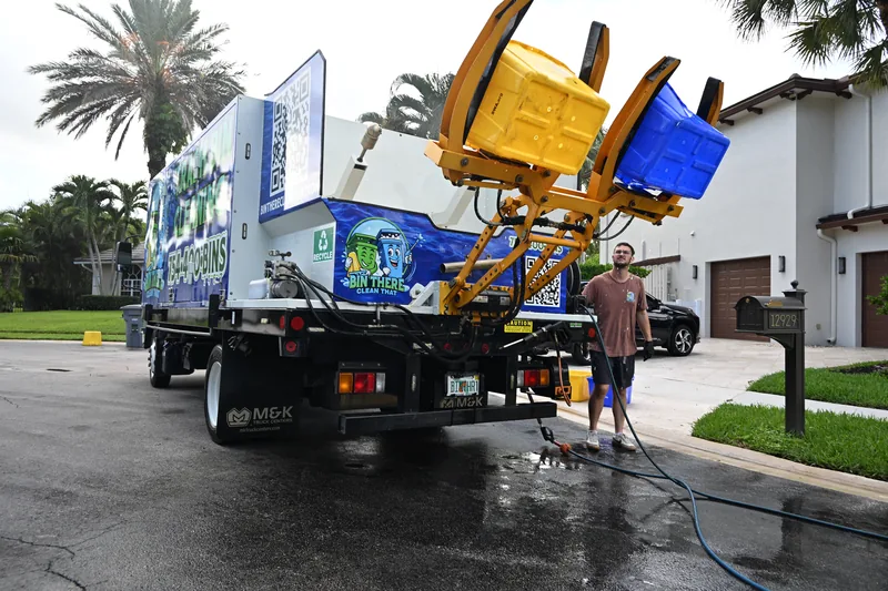 Bin There Clean That truck lifting two trash cans for cleaning